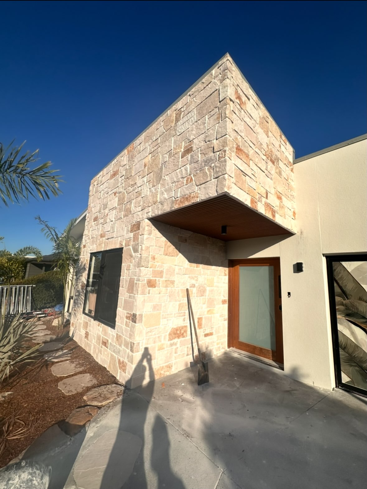 Coastal Stoneworks stone-clad gable and timber entrance