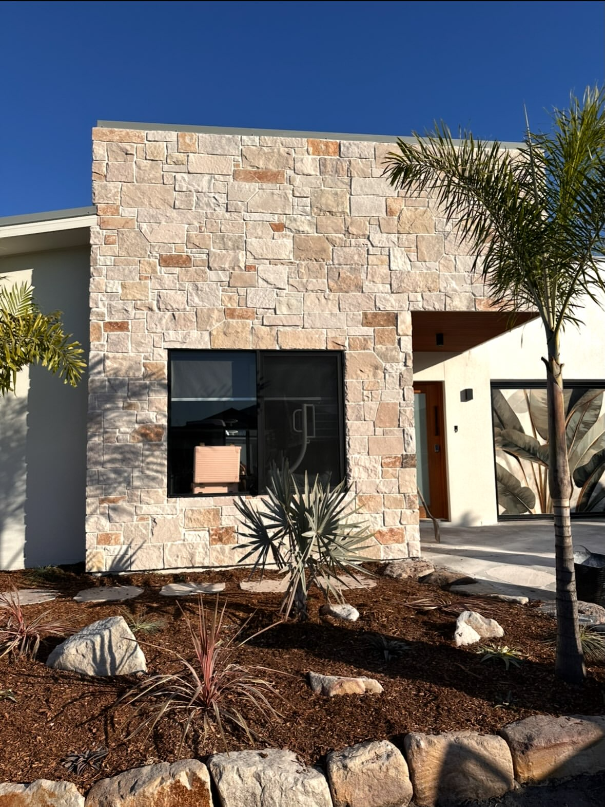 Natural stone facade surrounding a window and entrance