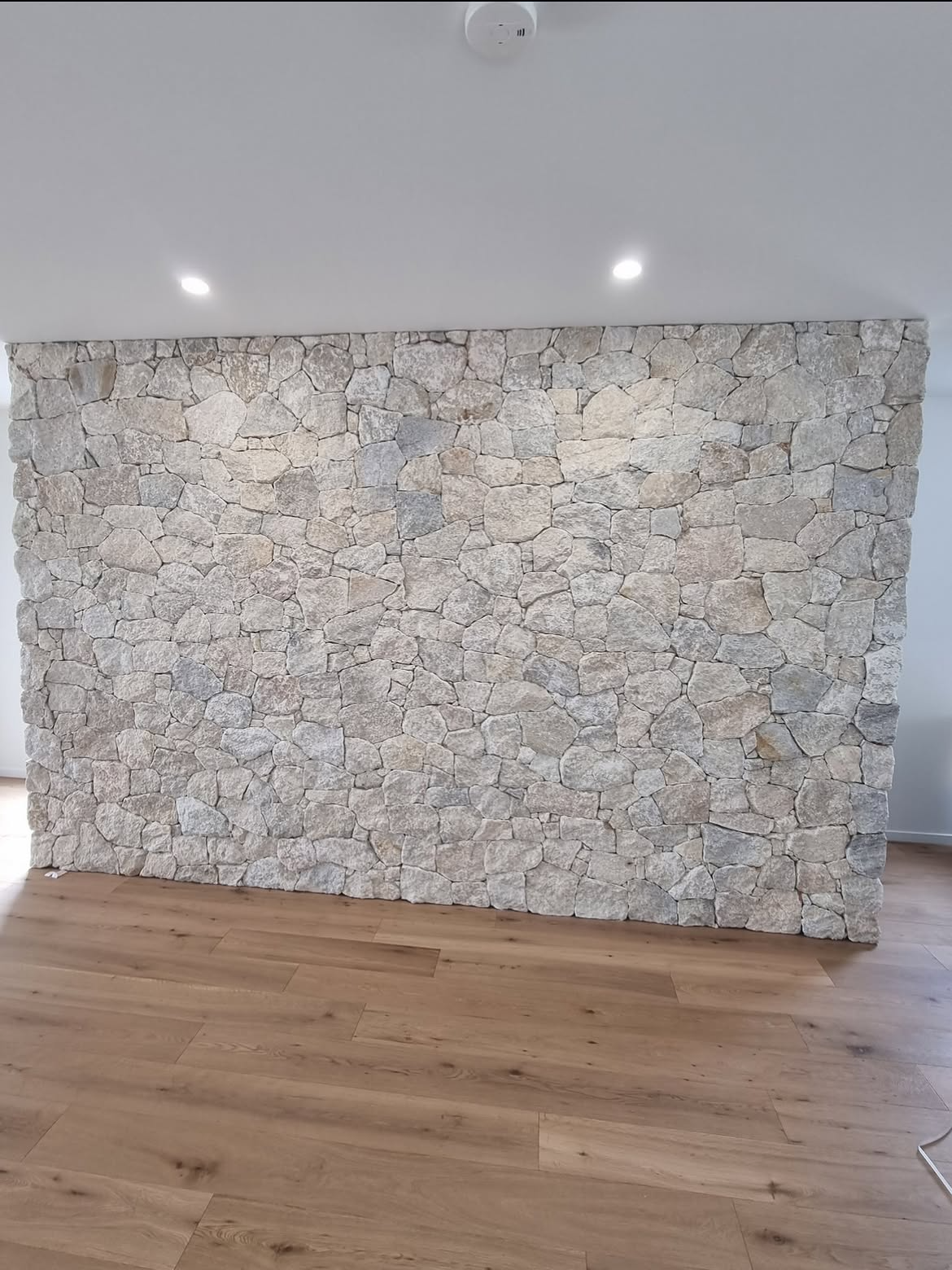 Grouted natural stone interior feature wall above timber flooring